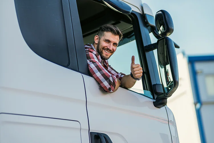 Zufriedener Truck-Fahrer lächelt und symbolisiert seine Zufriedenheit mit dem sehr sauber gewaschenen LKW von Brummi Dusche in Düren.